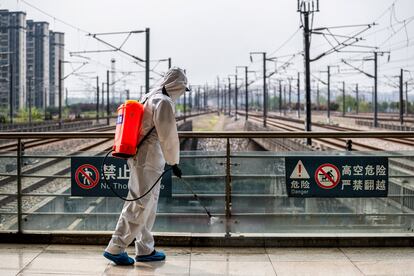 Un trabajador desinfecta la estación de tren de Wuhan, en marzo.