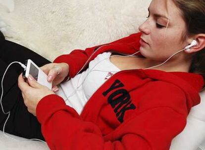 Una joven escucha música en un iPod.