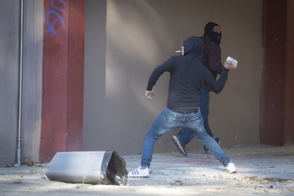 Un manifestante lanza una piedra a la policía durante los disturbios.