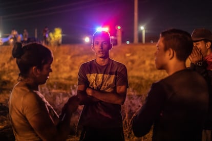 La frontera entre México y EE UU, una línea de 3.200 kilómetros de longitud, ha estado blindada estos días por unos 24.000 agentes. En la imagen, un grupo de migrantes venezolanos alumbrados por las luces de un coche patrulla, en Ciudad Juárez.