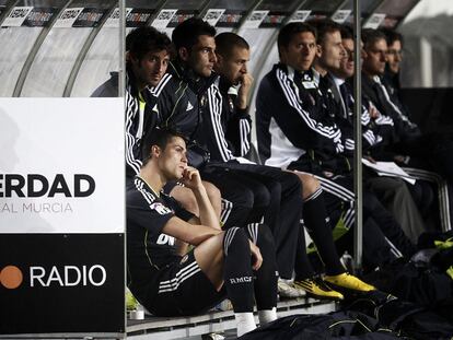 Cristiano Ronaldo (abajo) y Benzema (el tercero por la izquierda), en el banquillo.