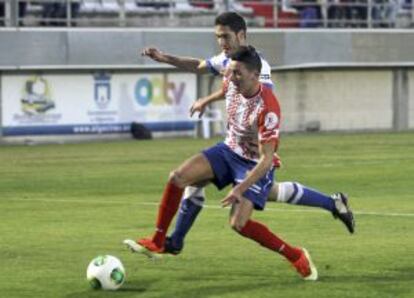 El centrocampista del Algeciras Jesús Ayala lucha un balón con Elustondo.