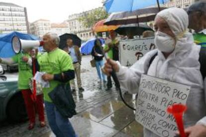 Personas afectadas por las participaciones preferentes de Novacaixagalicia, se concentran en la plaza de Armas de Ferrol junto a una de las sucursales de esta entidad para exigir que les reintegren todo el capital invertido. EFE/Archivo