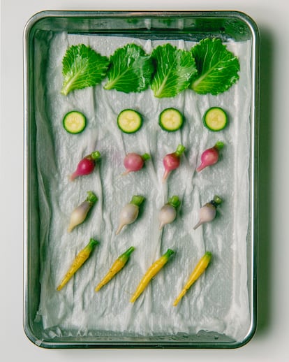 Verduras y tubérculos miniatura para utilizar en diversos platos, dispuestos sobre una bandeja en la cocina de Noor.