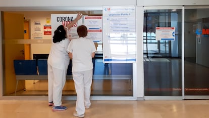 Dos enfermeras colocan un cartel con recomendaciones para el coronavirus en la sala de urgencias del Hospital Clínico San Carlos.