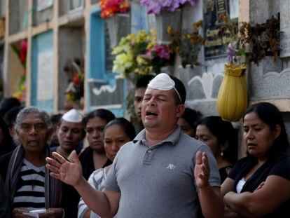 Un hombre reza en un funeral