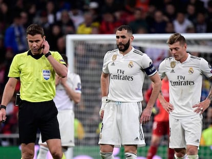 El árbitro Felix Brych en el partido de este martes. Detrás, los jugadores del Madrid Benzema (izquierda) y Kroos.