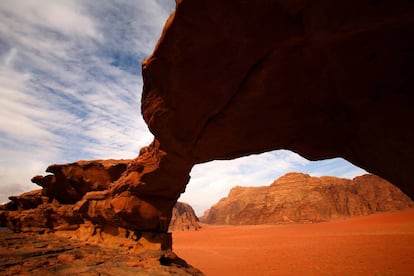 Los insólitos paisajes del Wadi Rum, un desierto de Jordania en la frontera con Arabia Saudí, han fascinado a todo tipo de viajeros. Uno de ellos fue el galés Thomas Edward Lawrence, el famoso Lawrence de Arabia (1888-1935), arqueólogo y escritor, oficial del Ejército británico durante la Primera Guerra Mundial. Unos paisajes que en su libro autobiográfico <i><b>Los siete pilares de la sabiduría</i></b> (Ediciones B) describe como “vasto, divino y lleno de ecos”. <br></br>En la imagen, arco de arenisca en el desierto de Wadi Rum, en Jordania.