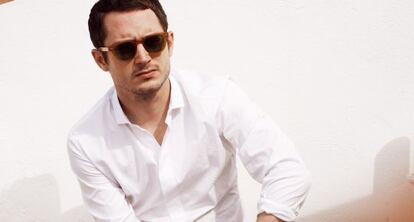 Elijah Wood ensayando la postura del hombre seductor y misterioso. Pues eso, Frodo luce camisa blanca de Mirto, pantalones de Dior y gafas de sol de Oliver Peoples.