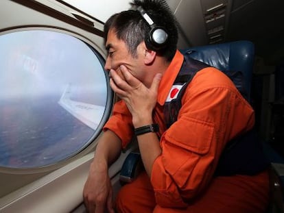 Koji Kubota, um salva-vidas japonês, observa o oceano em um Gulfstream V em busca do MH370.