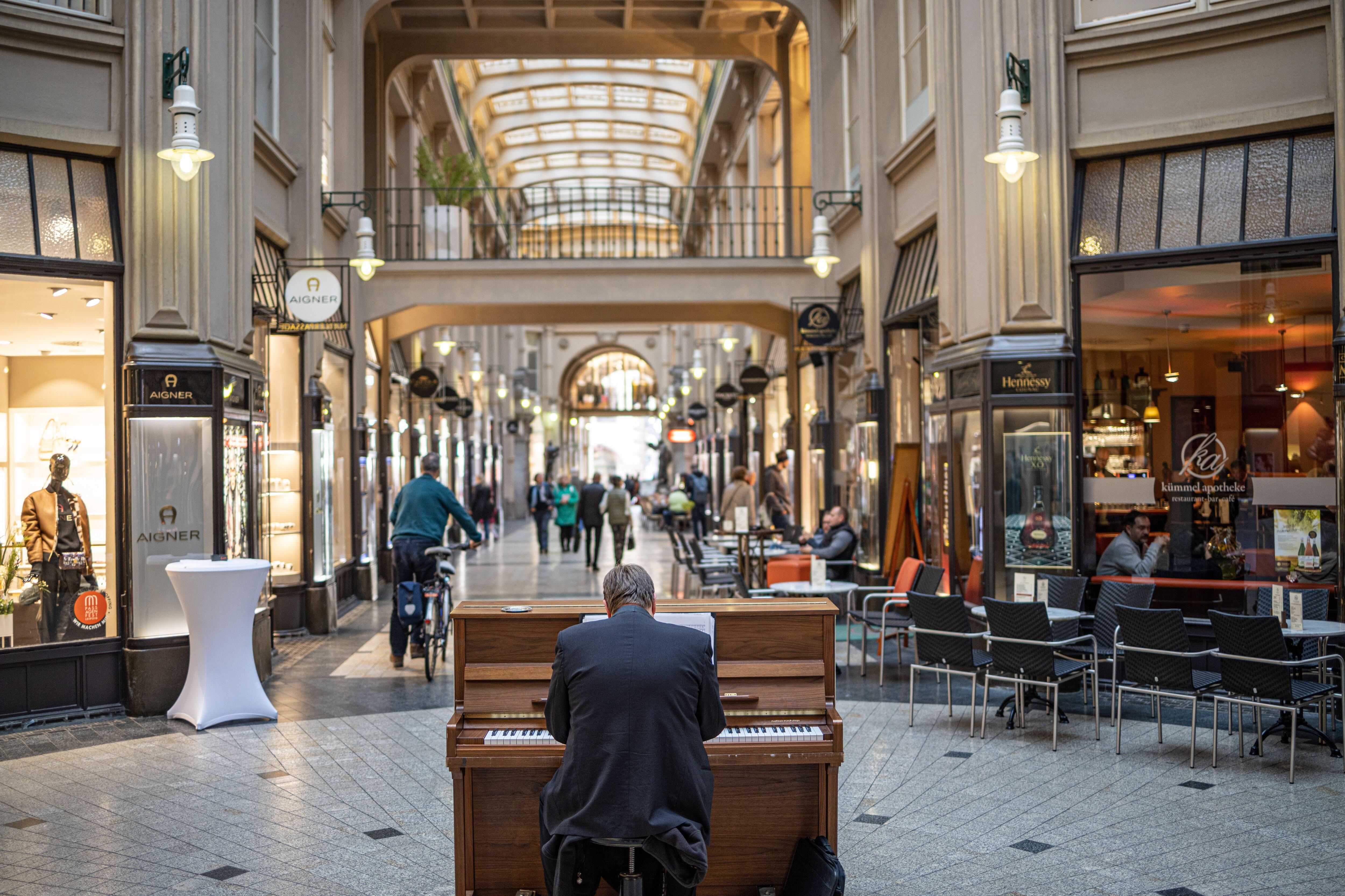 Un hombre toca el piano en el pasaje Mädler.