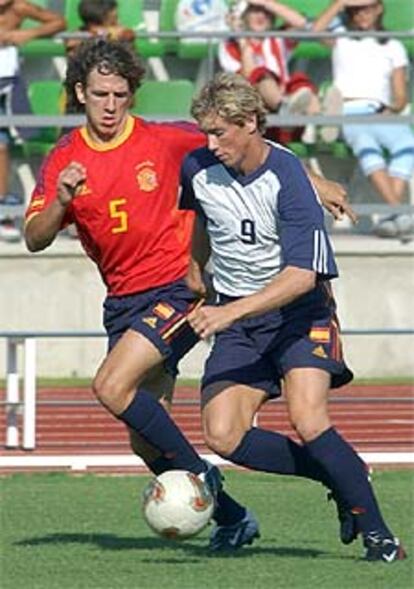 Puyol, a la izquierda, disputa el balón a Torres durante el partido.