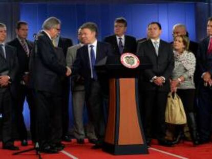 Fotografía cedida por la Presidencia de Colombia del mandatario Juan Manuel Santos (c) estrechando la mano del presidente de la Sociedad de Agricultores de Colombia (SAC), Rafael Mejía (i) en Bogotá (Colombia). EFE/Archivo