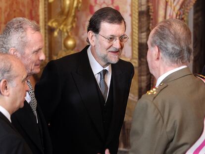 Jorge Fernández Díaz, Pedro Morenés y Mariano Rajoy conversan con el Rey durante la recepción de la Pascua Militar.