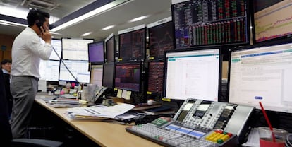 Un corredor de bolsa trabaja frente a monitores en el KEB Hana Bank en Seúl (Corea del Sur).