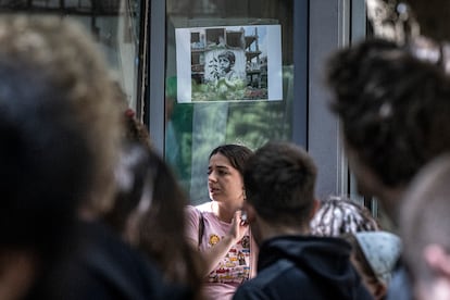 Estudiantes protestan en la facultad de Filosofía de la Universitat de València. Al fondo, una imagen de una vivienda destruida por los ataques israelíes con un grafiti de un niño llorando.