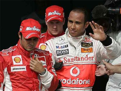 Lewis Hamilton saluda con la mano junto a Felipe Massa y, detrás, Kimi Raikkonen.
