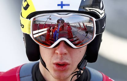 Compañeros de salto se reflejan en las gafas de Ilkka Herola, de Finlandia, durante el entrenamiento para la combinada nórdica masculina, el 13 de febrero.