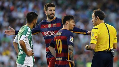 Piqué protesta al árbitro Mateu Lahoz tras recibir una tarjeta amarilla, en presencia de Leo Messi durante el partido contra el Betis.