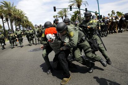 Forças de segurança do condado de Orange prendem um manifestante diante do Centro de Convenções de Anaheim, Califórnia (EUA), onde o candidato republicano à presidência dos Estados Unidos, Donald Trump, realizava um comício em 25 de maio de 2016.