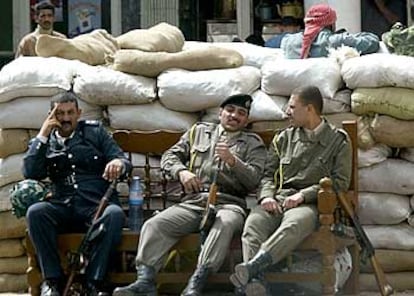 Soldados iraquíes descansan delante de unos sacos de arena colocados a modo de barricada para defenderse ante un posible ataque estadounidense.