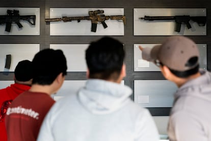 Customers look at AR-15-style rifles on a mostly empty display wall at Rainier Arms Friday, April 14, 2023, in Auburn, Wash