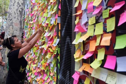 Una mujer coloca un mensaje de apoyo en un puesto de Las Ramblas de Barcelona.