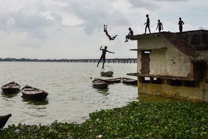 Un grupo de jóvenes salta desde una casa parcialmente sumergida en la orilla del río Ganges después de que el nivel del agua subiera tras las lluvias monzónicas, en el área de Jushi, en Allahabad (India), este viernes.