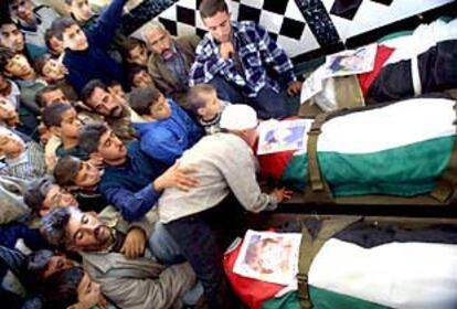 Asistentes al entierro de los cinco niños palestinos, ayer en Gaza, ante tres de los cadáveres.