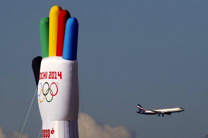 Un avión pasa junto a un globo en forma de mano con el logotipo de Sochi 2014 en el parque Olímpico, en el distrito de Adler, en Sochi, sede de los Juegos Olímpicos de Invierno 2014