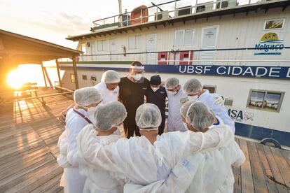 Personal médico reza junto a una Unidad de Salud móvil, en Ilha de Marajo (Brasil)