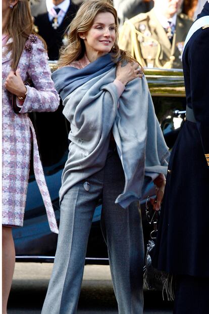 La Princesa de Asturias sorprendió en este día con un enorme chal para protegerse del frío. Era 2010 y Doña Letizia eligió también una blusa nude y pantalón ancho gris de Felipe Varela. El chal de lana en tonos grises le restaba formalidad a todo el look.