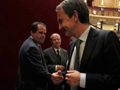 Zapatero sonríe al paso del diputado de la CC, José Luis Perestelo, durante el debate sobre los Propuestos del 2011.