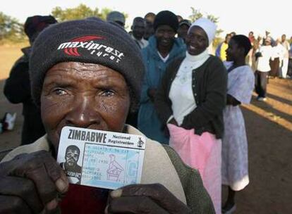 Una votante muestra su documento de identidad ante un colegio electoral de Bulawayo, feudo de la oposición al presidente Robert Mugabe.