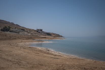 Vista de la orilla en una de las zonas del Mar Muerto con un complejo hotelero al fondo. Los afluentes que desembocan en el río están siendo desviados para fines agrícolas, para llevar agua a la población y para llenar las piscinas de los complejos turísticos de la zona. Se calcula que, desde hace décadas, el agua del Mar Muerto está retrocediendo a razón de un metro por año, hecho que preocupa a investigadores y científicos.