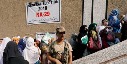 Army soldier stands guards where electoral workers gather to collect election materials at distribution point, ahead of general election in Peshawar