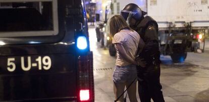 Un agente detiene a una manifestante en la Puerta del Sol.