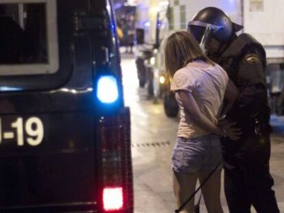 Un agente detiene a una manifestante en la Puerta del Sol.