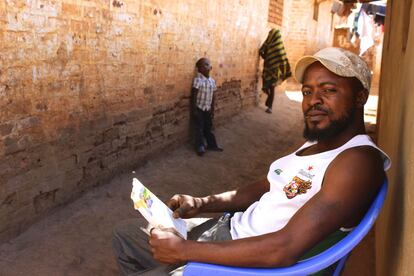 Passino Ngoie lee la prensa sentado a la puerta de su casa. Este electricista, llegado desde la República Democrática del Congo en 2009, es un ejemplo de cómo los refugiados se resignan ante la legislación malauí que les impide trabajar fuera del campamento.