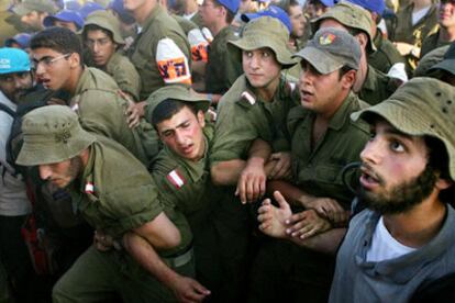 Soldados israelíes tratan de contener a los manifestantes que apoyan a los colonos de Gaza, hoy en la entrada de Kfar Maimon, al sur del país.