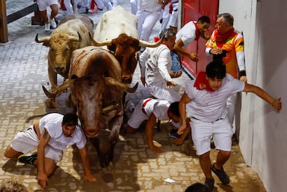 Varios mozos caen al suelo en la entrada del callejón de la plaza de toros de Pamplona, este viernes durante el sexto encierro. 