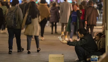 Dos personas pidiendo limosna en el paseo de Gràcia de Barcelona.