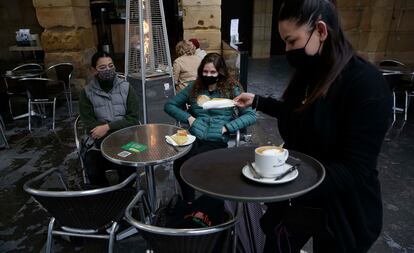 Una camarera atienda a unas clientas en una terraza de San Sebastián (Gipuzkoa).