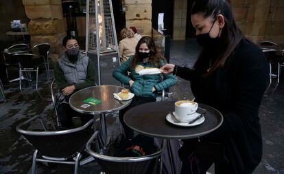 Una camarera atienda a unas clientas en una terraza de San Sebastián (Gipuzkoa). 