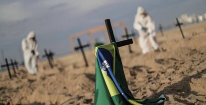 Activistas colocan ciento diez cruces para denunciar los errores cometidos por el Gobierno brasileño en la gestión de la crisis del coronavirus, durante un acto organizado por la ONG Rio de Paz este jueves, en la playa de Copacabana, Río de Janeiro. 