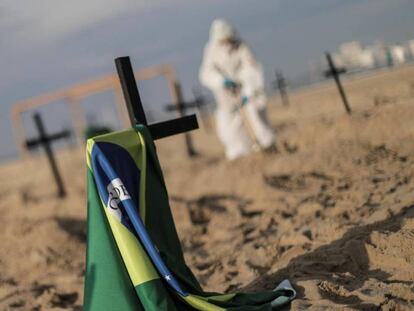 Activistas colocan ciento diez cruces para denunciar los errores cometidos por el Gobierno brasileño en la gestión de la crisis del coronavirus, durante un acto organizado por la ONG Rio de Paz este jueves, en la playa de Copacabana, Río de Janeiro.