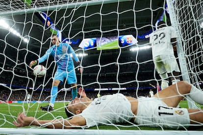 Lucas Vázquez, en el suelo, entre Lunin y Rüdiger tras un gol del Barcelona.