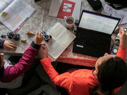 Una mujer teletrabajando junto a su hijo.