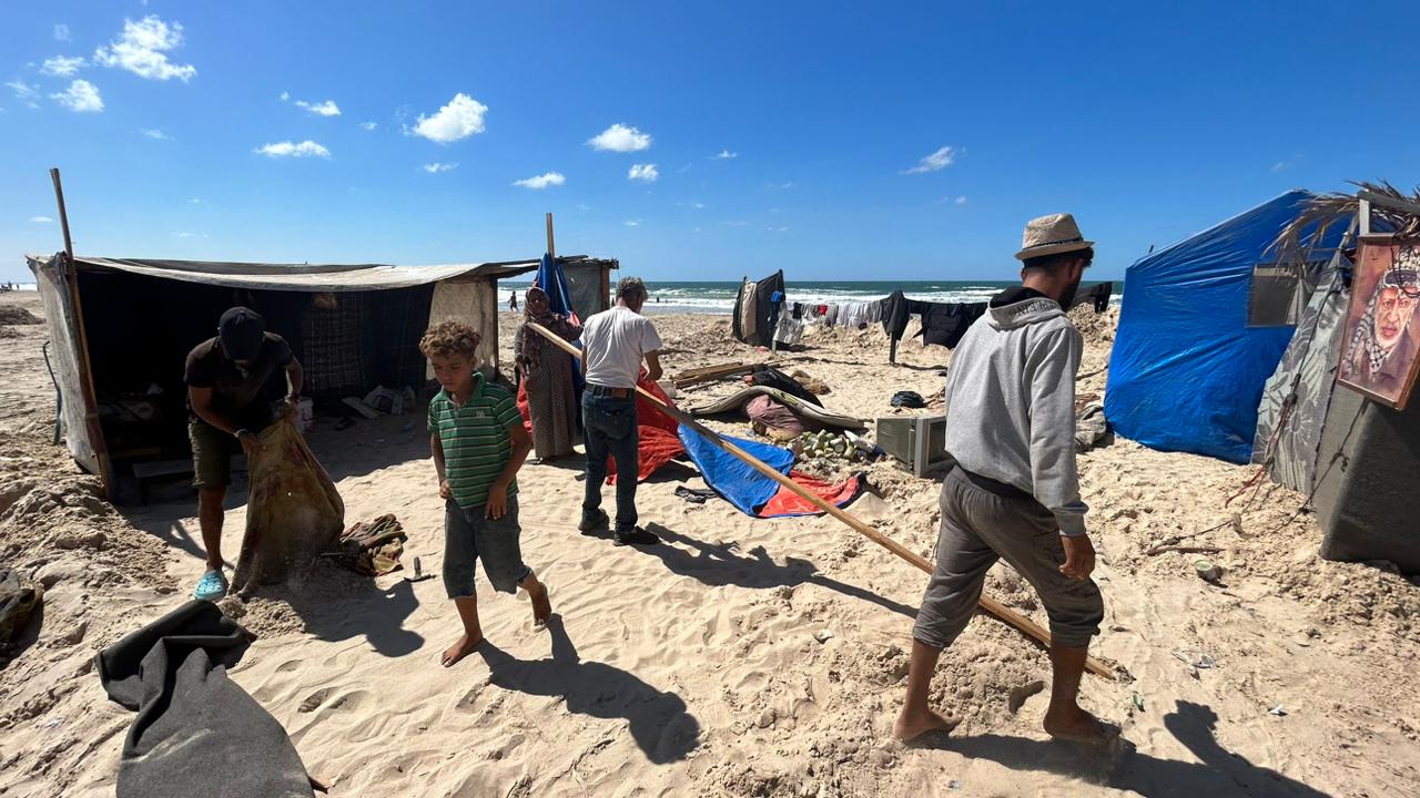 Ahmed al Zaqzuq y su familia preparan sus escasas pertenencias para trasladarse a un lugar más seguro, después de que su tienda de campaña se viera inundada por la marea en la zona de Al Mawasi, en el sur de la franja de Gaza, el 17 de septiembre de 2024.