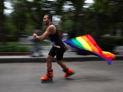 Un hombre patina con una bandera arcoíris, símbolo de la comunidad LGTBI, para celebrar la diversidad sexual, en la Ciudad de México, en 2021.